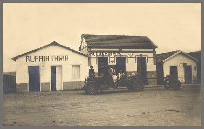 Foto de dois estabelecimentos comerciais de Coroados, uma alfaiataria e um açougue.